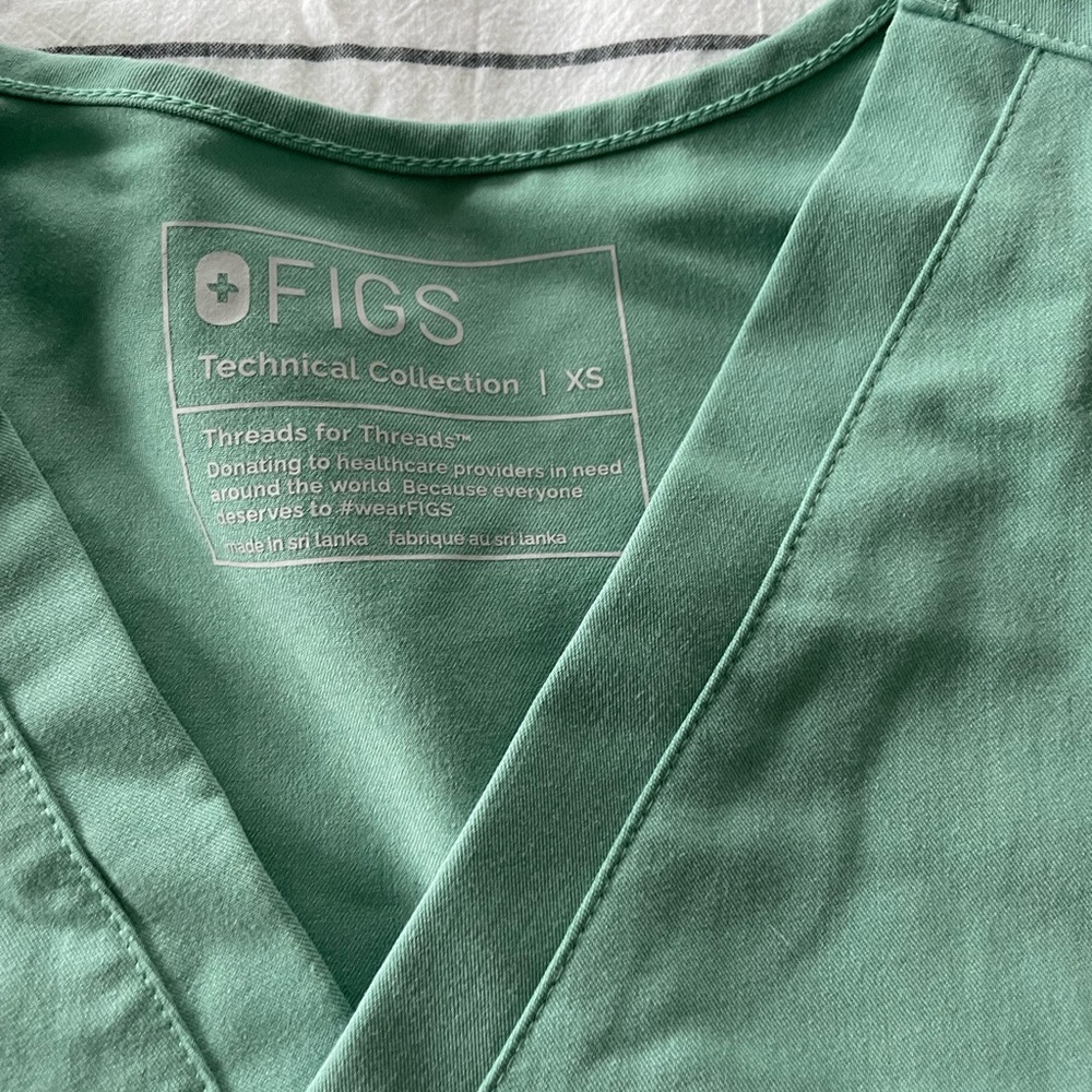 Green scrub top. One pocket. Figs XS.